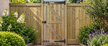 Pedestrian timber gate installation between wooden gate posts showing hinges, latch and full-lengthgate stop