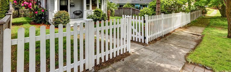 White Picket Fence with a gate leading into a home