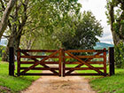 Two field gates closed and painted dark brown on a driveway