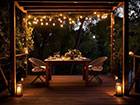 A romantic setting for two under a fairy light lit Pergola