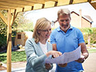 A couple checking their Bespoke Pergola drawings